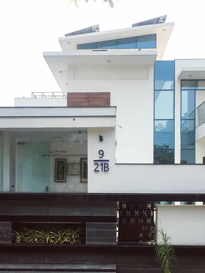 The clean, contemporary facade of Villa 9/21B in Faridabad. This project highlights our expertise in modern villa architecture, using a minimalist palette of white render, glass, and wood accents to create a home that is both striking and serene.