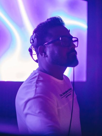 A moment of focus in a purple-lit club. My philosophy is to keep innovating and stay on top of my game to deliver the best for the audience.