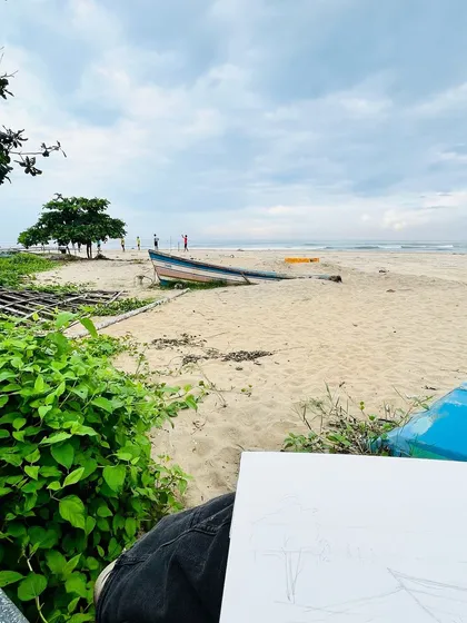 This was my view while painting on a quiet beach in my hometown in Kerala. The fishing boat, the clouds, and the lush greenery are scenes that feel like home and inspire me deeply.