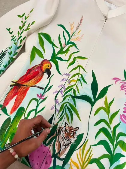 A process shot of the forest-themed jacket, showing me painting a tiger hidden amongst the leaves. I love adding small, surprising details to my work.