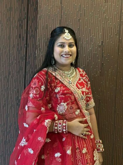 A close-up look at the blouse and dupatta of this traditional red bridal lehenga. The heavy embroidery and matching jewellery set create a complete and royal look.