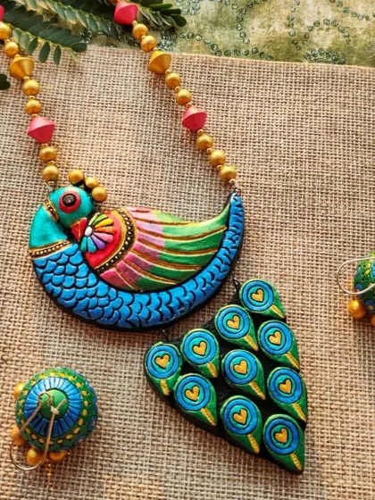 A full view of the stunning peacock necklace set, showing the pendant, the colorful beads on the chain, and the matching jhumkas.