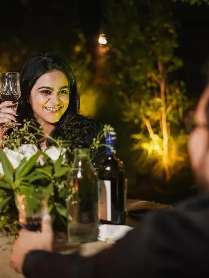 We focus on capturing individual expressions during a couple's shoot. Here, her happy smile over a glass of wine tells a story of love and celebration.