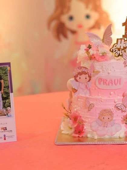 A close-up of the angel-themed first birthday cake, showing the delicate details.