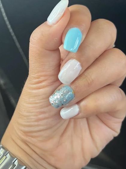 A cool-toned color palette of sky blue, white, and a silver glitter accent nail. This combination is fresh, bright, and perfect for a fun, summery vibe.