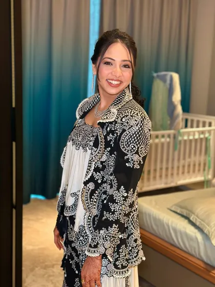 A full-length shot showing the unique and stylish outfit. The makeup is designed to be chic and modern to match her fashion-forward choice.