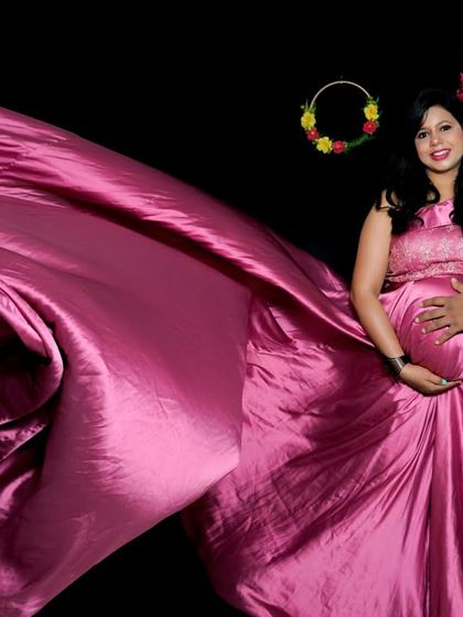 A dynamic studio shot with a flowing pink gown creating a dramatic effect. The couple stands together, creating a portrait that is both artistic and deeply connected.