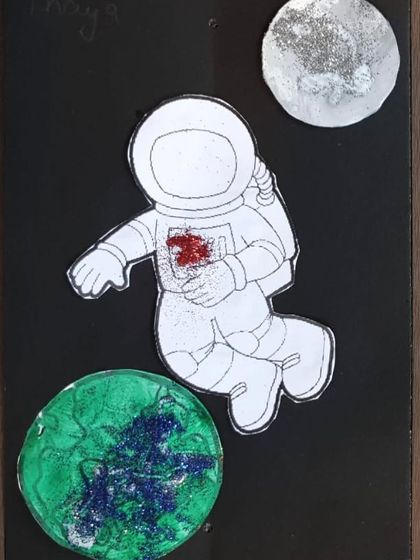 The finished product from our Space Week. This astronaut art piece combines painting and glitter work to create a cosmic scene, perfect for any young space explorer.