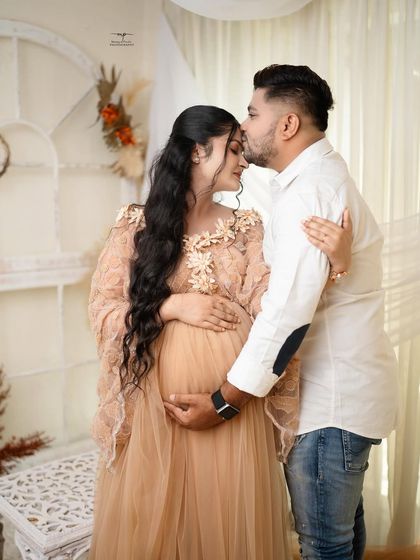 A tender kiss on the forehead. This classic pose, set against the warm, neutral backdrop of the boho studio, is a timeless expression of love and care.