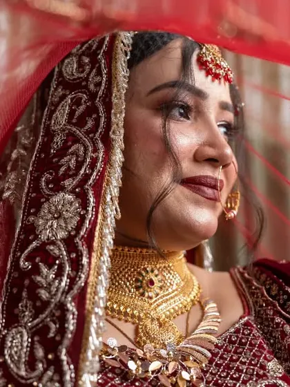A classic bridal portrait, with the bride's face gently framed by her red veil. We specialize in creating elegant and timeless solo portraits that highlight the bride's beauty and emotion on her special day.