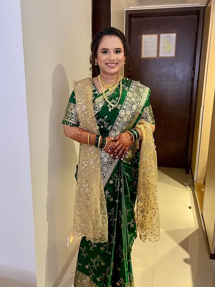 A full-length view of the bride in her stunning green Paithani. The makeup is balanced to look beautiful from afar and up close.