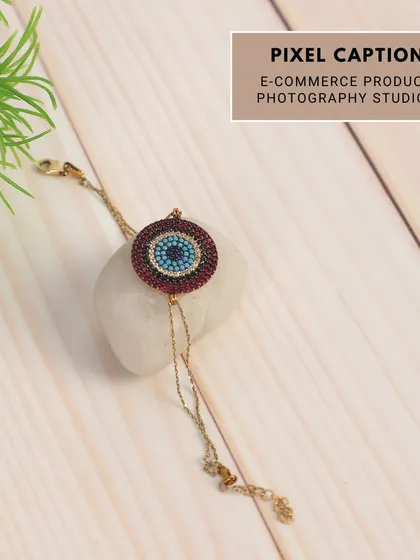A creative shot of a bracelet styled with a white stone and a plant. This brings a fresh, natural element to the product photography, ideal for lifestyle brands.