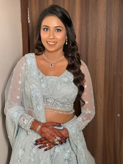 A full-length view of the bride's beautiful pastel blue reception lehenga. The soft makeup complements the color of the outfit perfectly.