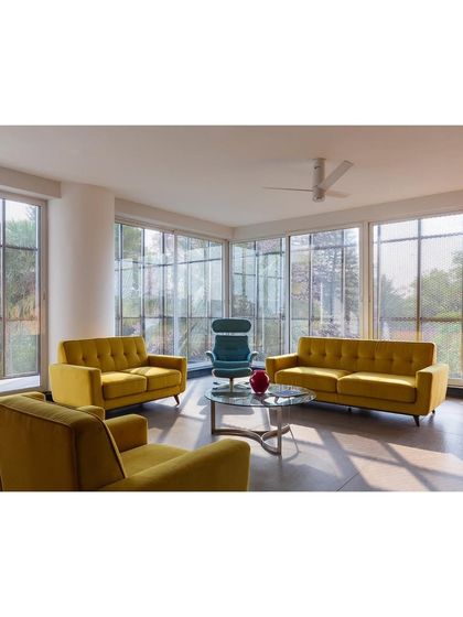 The interior of 'Hoverspace' is a column-free environment where structural trusses are celebrated as sculptural red elements. Minimalist furniture and extensive use of glass for partitions create a transparent, light-filled, and collaborative workspace.