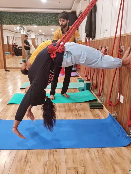 A suspended forward bend using the ropes provides a deep release for the entire back body, serving as a perfect counterpose after intensive backbending work.