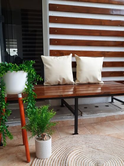 A closer look at the polished pinewood bench and wall panelling. The clean lines and warm wood tones create a sophisticated and comfortable seating area, perfect for an urban balcony.