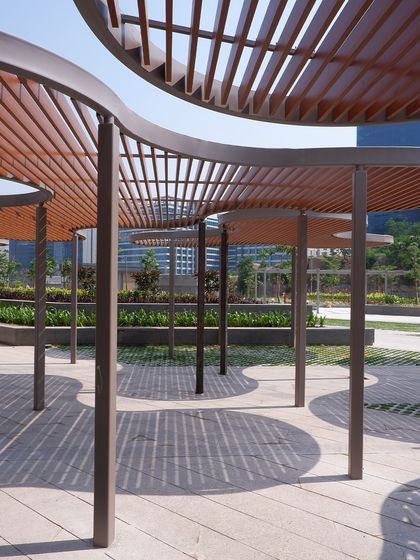 The design of the pergolas at KRC Hetero Commerzone is inspired by the play of light and shadow. The curved, slatted structures create dynamic patterns on the ground while providing essential shade, making the outdoor plaza a comfortable and visually engaging space.