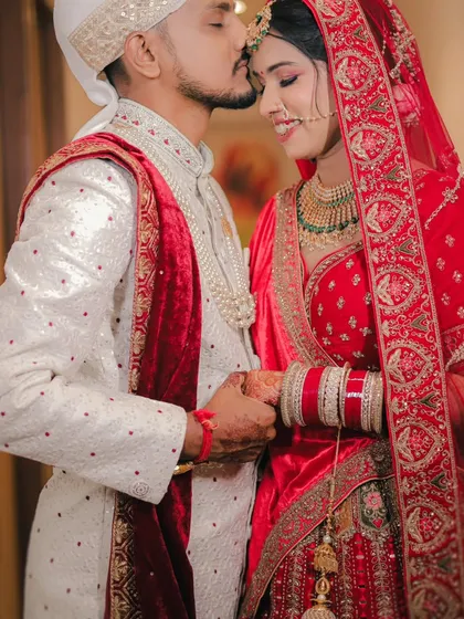 A tender moment between the bride and groom. The groom's forehead kiss and their gentle hold create a portrait full of love and warmth.