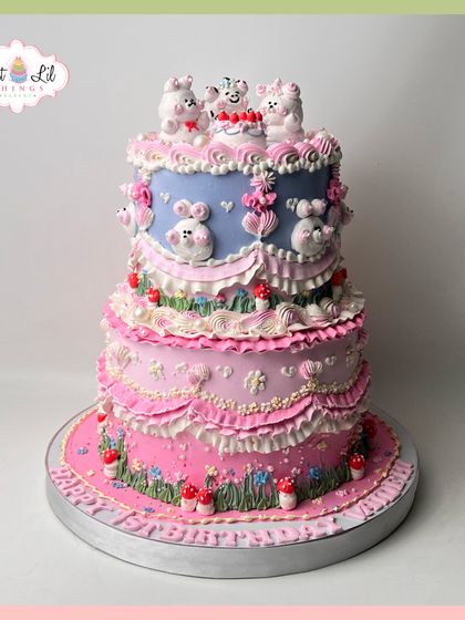 A whimsical vintage-inspired birthday cake. This two-tiered creation is adorned with adorable bears, ruffled frosting, and tiny mushrooms for a fairytale look.