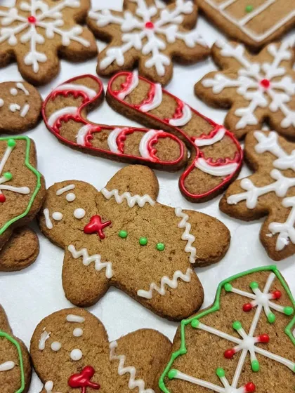 A close-up of our hand-decorated gingerbread cookies for Christmas. Each cookie, from the gingerbread men to the candy canes and snowflakes, is decorated with royal icing to bring out the festive details.