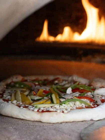 The heart of Italian cooking is simplicity and quality. Here, a fresh vegetarian pizza with a sourdough base and vibrant toppings is prepared in our authentic wood-fired oven, delivering a rustic and gourmet taste of Italy to your celebration.