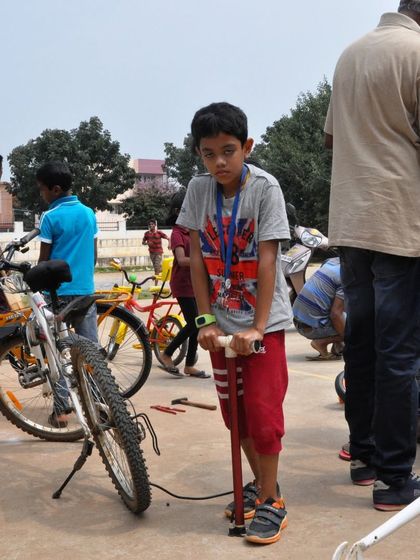 A young participant gets ready to pump up a tire at one of our community workshops. We teach kids to handle basic tools and perform routine checks, empowering them to be self sufficient with their bikes.