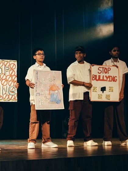 The final pose, holding signs created by the students themselves. This performance was a project in courage, teamwork, and using art to create awareness.
