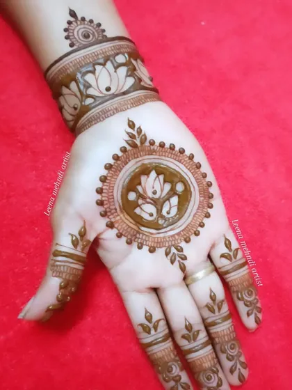 A simple and sweet mandala design with a lotus at its heart. The wrist cuff has a matching lotus band, and the fingers have delicate leafy patterns.