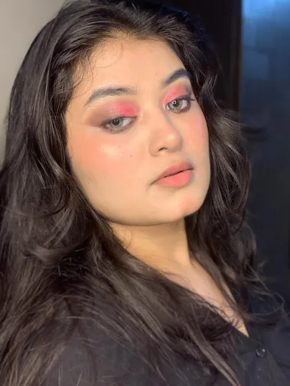 A pop of pink on the eyes can make a statement. This look combines a neutral smokey eye with a bright inner corner highlight.