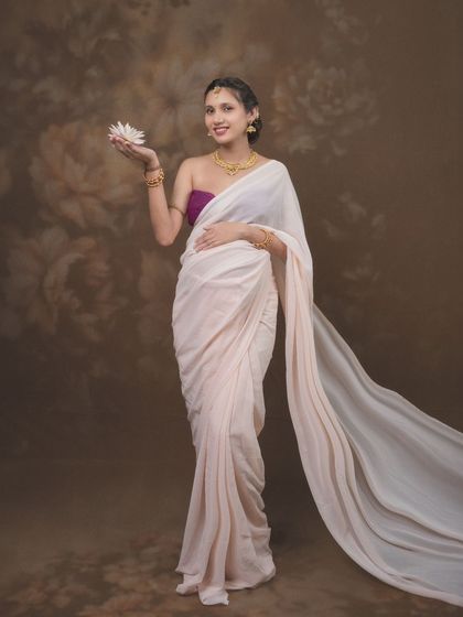 Beauty, grace, and the gentle strength of a blossoming mother captured in a single frame, wearing a delicate white saree.