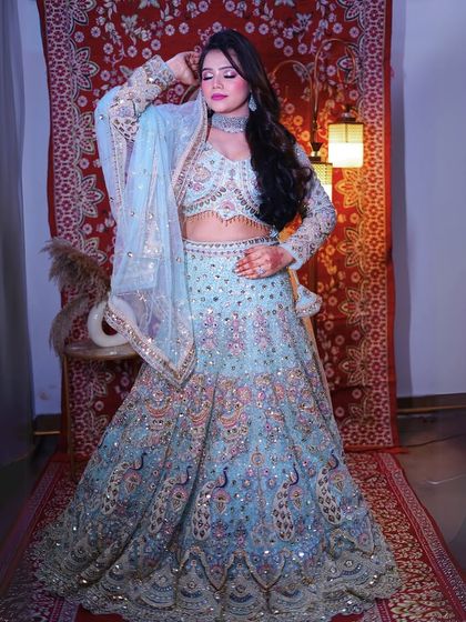 This stunning powder blue lehenga with peacock embroidery is a true work of art. It's perfect for creating a regal and unique bridal or reception look.