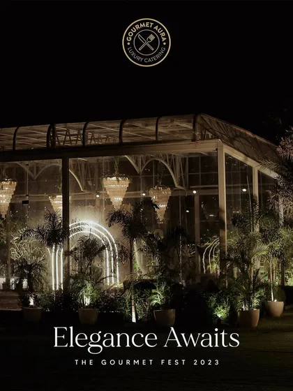 Elegance awaits. A stunning outdoor venue at night, set for The Gourmet Fest 2023, with grand chandeliers and lush greenery. We transform any space into a breathtaking setting for an unforgettable celebration.