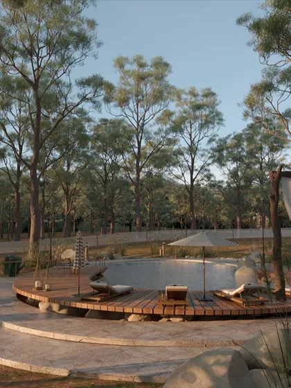 The wooden deck curves around the pool, providing ample space for sun loungers. The choice of natural wood for the decking ensures it feels warm and comfortable underfoot, further connecting the space to its natural surroundings.