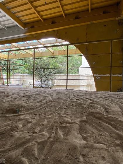 The interior of a commercial building during its transformation. The raw floor and exposed new structural arches hint at the open, flexible office spaces to come, designed to meet the needs of modern information-driven businesses.