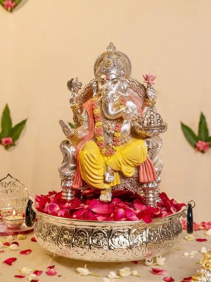 I believe in bringing divinity into the home with grace. This magnificent silver-plated Lord Ganesha idol, seated on a bed of delicate rose petals, radiates peace and regal blessings, making it a powerful centerpiece for your sacred space.