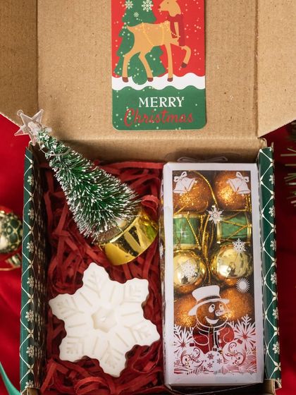 Another look at my charming and affordable Christmas gift box. It includes a mini Christmas tree, a snowflake candle, and a box of bauble-shaped chocolates.
