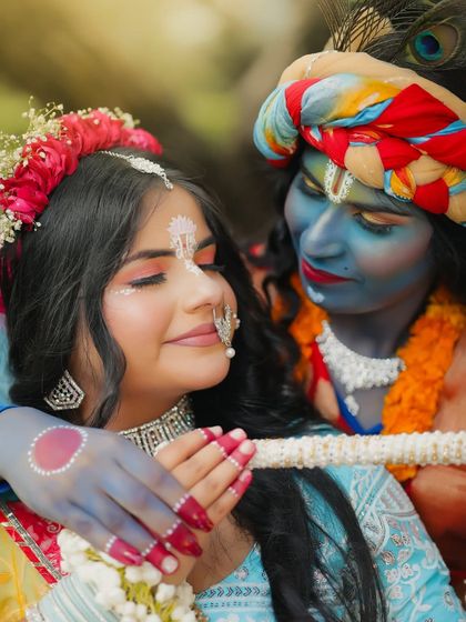 A close-up, emotional shot of Radha and Krishna, highlighting the delicate makeup details and expressions.