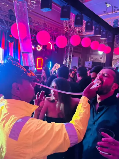We are all about creating high-energy, interactive moments. Here, one of our bartenders uses a custom shot dispenser to bring the party directly to the guests, ensuring the fun never stops.