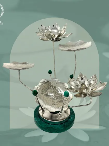 The Majesty Malachite Lotus Centerpiece. This stunning decorative piece features silver-plated lotus flowers and leaves rising from a solid malachite base, embodying regal elegance.