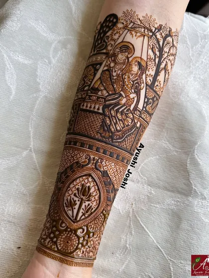 For me, mehendi is devotion. This full-sleeve design features a detailed portrait of Radha and Krishna on a swing, surrounded by divine motifs like peacocks, lotuses, and cows, creating a piece of wearable spiritual art.