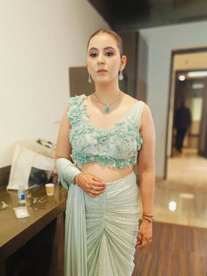 The client's full look, showing how the sleek low bun provides a perfect base for her elegant outfit and allows her jewelry to shine.