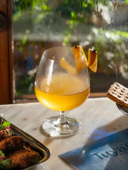 A smoky toddy captured by a window with natural light. The steam effect adds a cozy, comforting feel, ideal for promoting seasonal drinks.