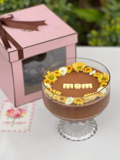A special chocolate mousse bowl I created for Mother's Day, decorated with fresh yellow and white flowers and the word "Mom." It's a hug in a bowl, perfect for showing your love.