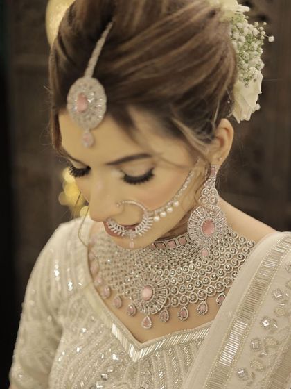 A close-up on the details. This image shows the beautiful updo with fresh white flowers and the stunning design of her diamond and pink stone jewelry.
