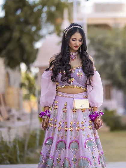 A portrait of a happy and chirpy Mehendi bride. Her lavender lehenga and floral jewelry perfectly match her fun-loving personality.
