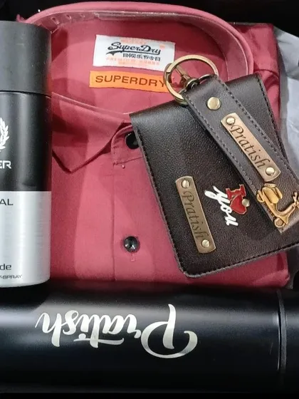 This gift set includes a personalized temperature bottle, a wallet and keychain with an anchor charm, a red shirt, and deodorant.