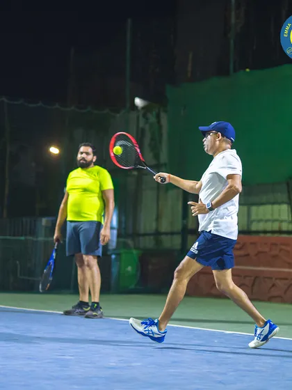With intense focus, a player prepares to hit a forehand during a doubles match. Our courts are the perfect setting for both competitive and recreational tennis.