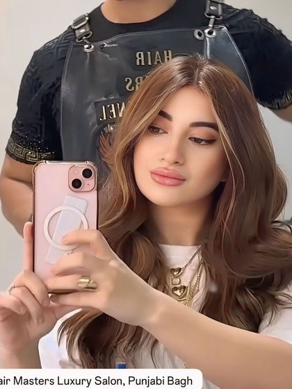 A happy client taking a selfie to show off her new 'money piece' transformation. The bright highlights around her face look fantastic.