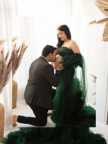 A classic and heartwarming pose. The father-to-be kisses the baby bump, a tender moment captured beautifully in our bright and airy studio setting.