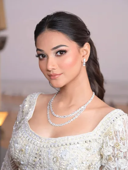 A portrait of modern elegance. The soft makeup and chic ponytail create a look that is both luxurious and effortlessly beautiful, perfect for a Sangeet or engagement.